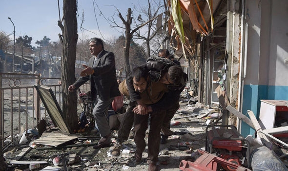 Afghan volunteers carry a body at the scene of a car bomb exploded in Kabul.
